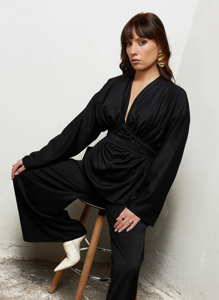 Blusa Hatshepsut nero ossidiana, drappeggiata con fusciacca, indossata dalla modella