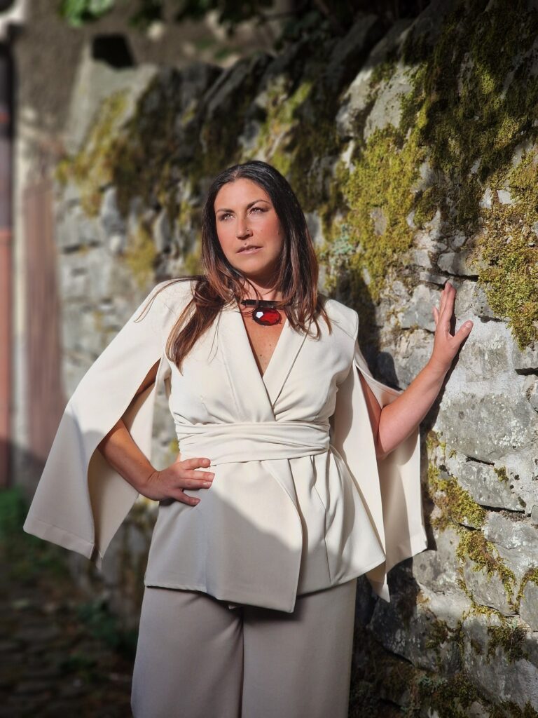 Giacca Atena avorio, con maniche a mantella e cintura, indossata dalla modella